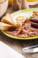 full engelsk frukost med bacon, korv, stekt ägg, bakad bea foto