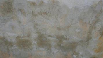 den gamla cementväggen var vittrad, ytan var repad, ytan var repad och skadad. för en mystisk retrokonservativ bakgrund. foto