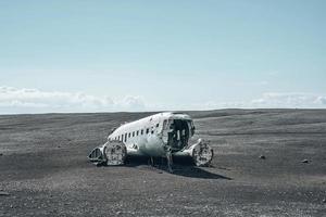 berömt trasigt flygplansvrak på svart sandstrand i solheimasandur mot himlen foto