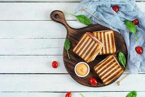 club sandwich med skinka, tomat, ost och spenat. grillad panini. toppvy foto