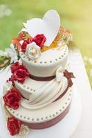 bröllopstårta med ätlig dekoration upplyst av solljuset