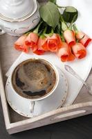 kopp kaffe och en bukett rosor