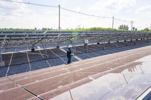solfarmen, solpanel med ingenjörer som går för att kontrollera systemets funktion, alternativ energi för att spara världens energi, idé för en solcellsmodul för produktion av ren energi foto