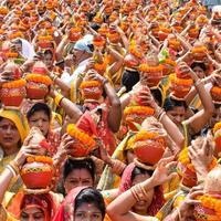 New Delhi, Indien 3 april 2022 - kvinnor med kalash på huvudet under jagannath-templet mangal kalash yatra, indiska hinduistiska hängivna bär jordkrukor som innehåller heligt vatten med en kokosnöt på toppen foto