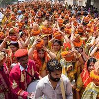 New Delhi, Indien 3 april 2022 - kvinnor med kalash på huvudet under jagannath-templet mangal kalash yatra, indiska hinduistiska hängivna bär jordkrukor som innehåller heligt vatten med en kokosnöt på toppen foto