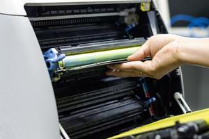 Tekniker som byter ut toner i laserskrivare koncept reparation av kontorsmateriel foto