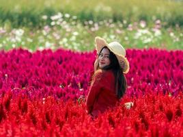 le glad asiatisk kvinna i färgglad röd celosia blomsterträdgård foto