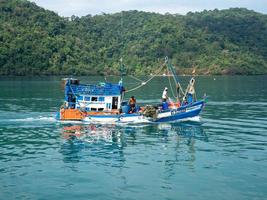 trat, thailand - 1 mars 2021 fiskebåt rör sig i grön blå havsö i thailand foto