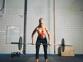 gym kvinna lyfta tunga vikter i gymmet foto