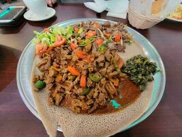etiopisk mat injera bröd med biff och tomater foto