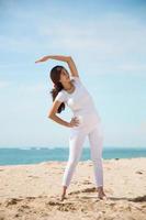 gravid asiatisk kvinna övning på stranden