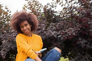 en glad och ung afroamerikansk student i parken foto