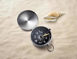 kompass på havssand. resmål och navigeringskoncept foto