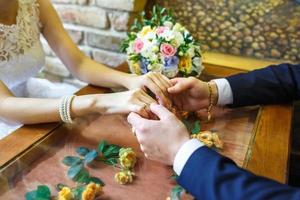 brudgummen håller händerna på sin brud på deras bröllopsdag foto
