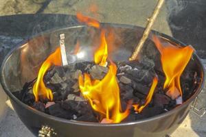 förbereder grill bbq lägereld och bränner ved med orange lågor. foto