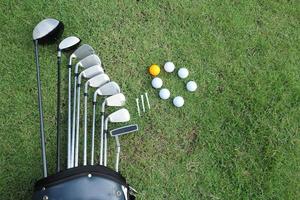 golfboll och golfklubb i påse på grönt gräs foto