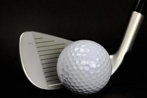 golfboll och klubb närbild på svart bakgrund foto