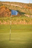 blå golfbana flagga som flyger i vinden