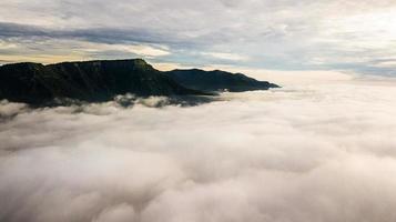 morgondimma med berg, soluppgång och hav av mis foto