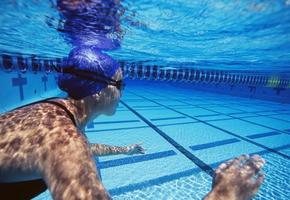 kaukasiska kvinnliga simmare som simmar i poolen foto