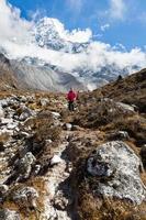 kvinna backpacker stående trail ama dablam berg. vertikal. foto