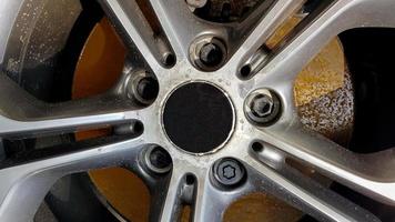den ursprungliga lättmetallfälgen, smutsig och repad på bilen närbild. slitna bilhjul väntar på reparation. selektiv fokusering. bilreparations- och restaureringskoncept krävs. skadat bilhjul. foto