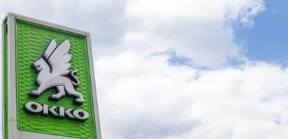 ett nätverk av bensinstationer i ukrainska okko med en butik och ett café. logotyp mot en blå himmel med moln. detaljhandel med petroleumprodukter. banner med kopia utrymme. Ukraina, Kiev - 23 maj 2022. foto