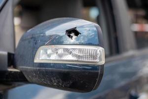 närbild trasig vänster backspegel av en bil i blått. bilförsäkring koncept. krossat sidoglas på bilen på förarsidan till följd av en olycka. kriminell händelse. foto