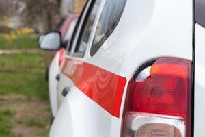 den bakre vänstra lyktan på en vit bil är trasig. baklyktan på bilen krossades vid olyckan. skadeolycka. säkerhetskoncept. bakre stopp av en bil i en olycka närbild. foto