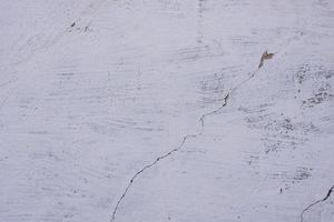 textur av en betongvägg med sprickor och repor som kan användas som bakgrund foto