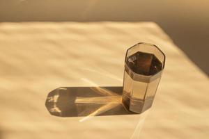 glas vatten på bordet med skuggor foto