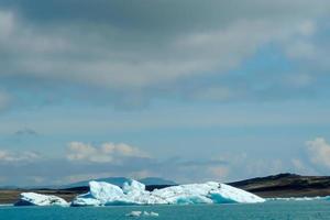 klarblått isberg som flyter i sjön jokulsarlon blått kallt vatten på Island 24 foto