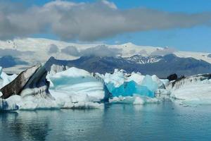 klarblått isberg som flyter i sjön jokulsarlon blått kallt vatten på Island 53 foto