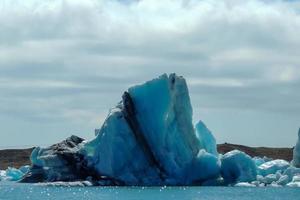 klarblått isberg som flyter i sjön jokulsarlon blått kallt vatten på Island 35 foto