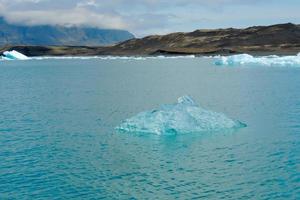 klarblått isberg som flyter i sjön jokulsarlon blått kallt vatten på Island 11 foto