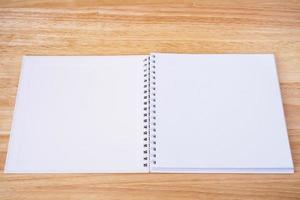 öppen anteckningsbok på träbordsbakgrund foto