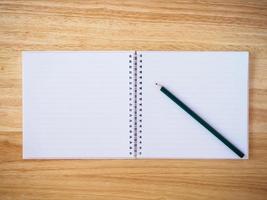 anteckningsbok ovanifrån med penna på brunt trä skrivbord foto