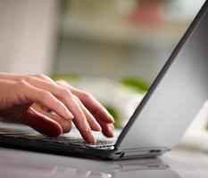 kvinna händer att skriva på laptop