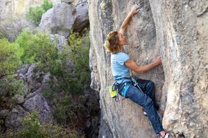 sporttjejen ägnar sig åt bergsklättring foto