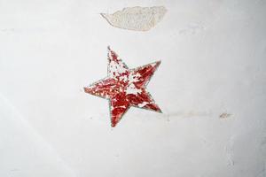 röd femuddig stjärna på den gamla väggen foto