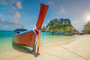 thai traditionella färgglada longtailbåt i trä och vacker sandstrand i thailand. foto