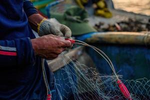 fiskare kastar sitt nät vid soluppgången eller solnedgången. traditionella fiskare förbereder fiskenätet foto