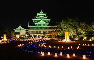 okayama slott med lyktor som lyser upp på natten i okayama, japan foto