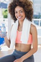 passar unga kvinnliga hållande vattenflaska på gymmet foto