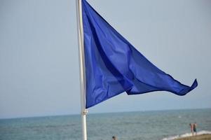 blå säkerhetsflagga på stranden foto
