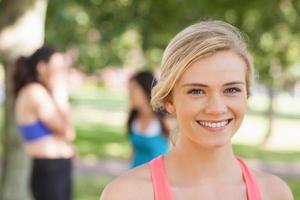vacker blond sportig kvinna poserar i en park foto