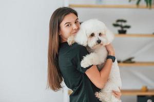kvinna som håller husdjuret. söt liten hund är i grooming studio foto