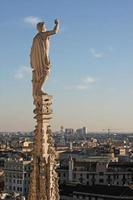 staty på Milanos katedral med ena knytnäven höjd mot himlen foto