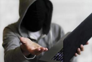 ransomware - hackare med bärbar dator som kräver pengar foto