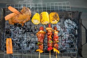 utsökt grillat kött med rök, bbq med grönsaker utomhus. grill, fest, livsstil och picknick koncept foto